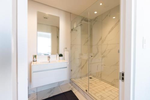 a bathroom with a sink and a glass shower at City Nest: Heart of Linksfield in Johannesburg