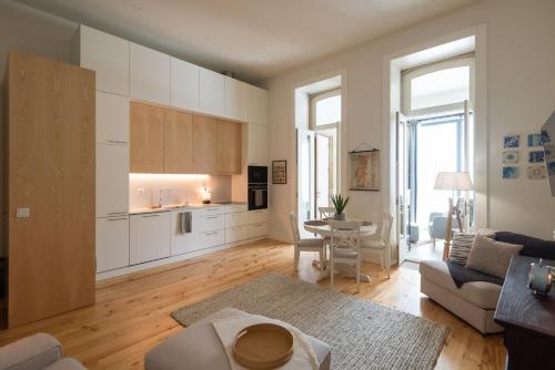 a kitchen and living room with a couch and a table at Porto Grandeur Collection - D. João IV Pool & Garden Apartment in Porto