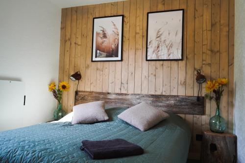una camera da letto con un letto e tre quadri sul muro di Wioska Radoska - Żółta Stodoła na mazurach przez cały rok a Lichtenstein Ostpreussen