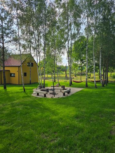 un parc avec un groupe de bancs dans l'herbe dans l'établissement Wioska Radoska - Żółta Stodoła, à Lichtenstein Ostpreussen