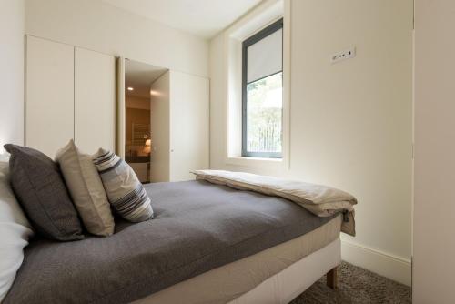 a bedroom with a bed with a window at Porto Grandeur Collection - D. João IV Pool & Garden Apartment in Porto