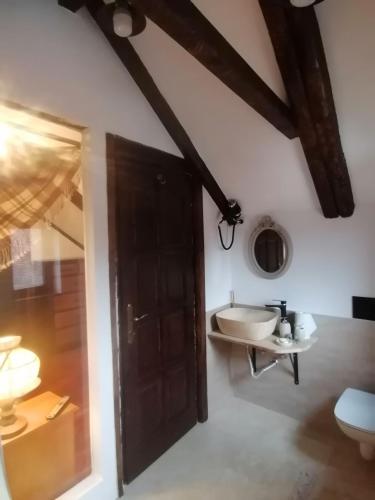 łazienka z drewnianymi drzwiami i umywalką w obiekcie Casa Huber w mieście Cîrţa