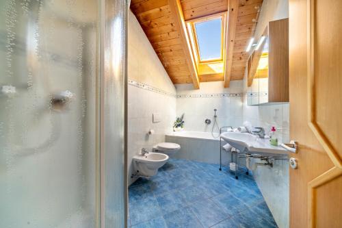 La salle de bains est pourvue d'un lavabo, de toilettes et d'une fenêtre. dans l'établissement Ferienhof Turmwirt Pink Leidy, à Lana