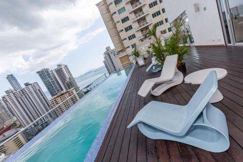 a balcony with chairs and a swimming pool on a building at Impressive City View Apartment Marbella - PH Quartier Marbella in Panama City