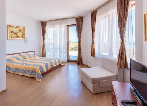 ソゾポルにあるVia Pontica 123 Guest Apartmentsのベッドルーム(ベッド1台、ソファ、テレビ付)