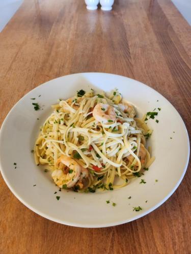 a plate of pasta with shrimp on a wooden table at Garth Hotel in Grantown on Spey