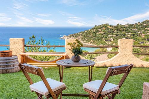 a patio with a table and chairs and the ocean at Sardinia Villa Torre delle Stelle in Torre delle Stelle