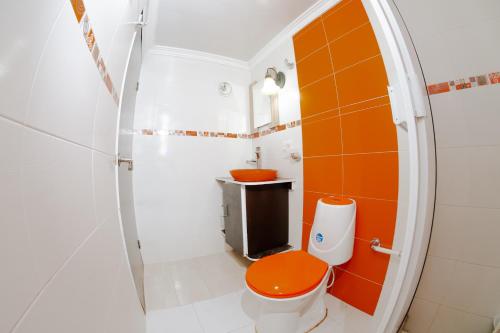a bathroom with an orange toilet and a sink at Hotel Campestre Dorado SAI in San Andrés