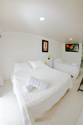 a white bedroom with a large white bed at Hotel Campestre Dorado SAI in San Andrés