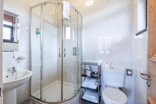 een badkamer met een douche, een toilet en een wastafel bij The Royal Hotel in Ullapool
