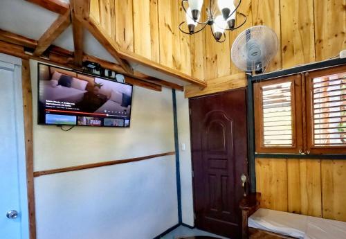 a room with a tv on the wall and a door at Rustic House Punta Rucia in Punta Rucia