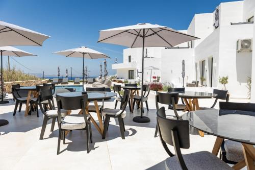a patio with tables and chairs and a pool at El Mar Naxos in Naxos Chora