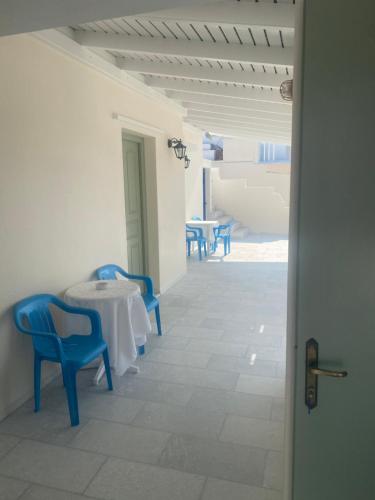 a white room with blue chairs and a table at Asiminas in Naxos Chora