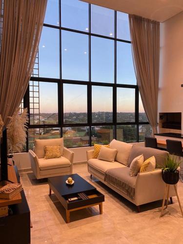 a living room with a couch and a large window at Departamento de lujo tipo dúplex in Ciudad del Este