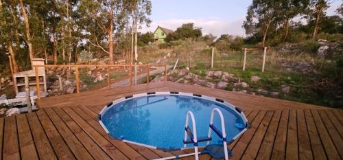 una piscina en una terraza de madera con una terraza de madera en Sol de Elefantes, en Villa Serrana