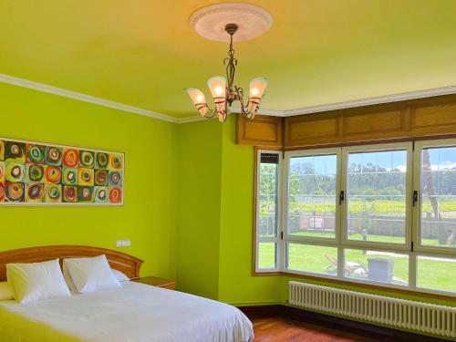 a green bedroom with a bed and two windows at Villa Remoan in Vilagarcia de Arousa