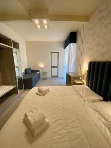 a bedroom with a large bed with two towels on it at Hotel Liu in Lido di Camaiore