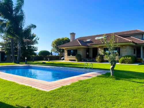 a house with a swimming pool in front of a house at Villa Remoan in Vilagarcia de Arousa
