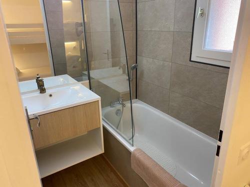 La salle de bains est pourvue d'une douche, d'un lavabo et d'une baignoire. dans l'établissement Appartement résidence vacances amandier, à Arles