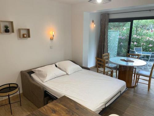 uma cama num quarto com mesa e mesa em Appartement résidence vacances amandier em Arles
