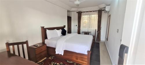 a bedroom with a white bed and a window at Downtown Virgins Hotel in Elmina