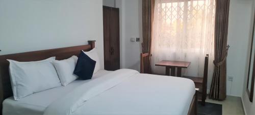 a bedroom with a white bed and a window at Downtown Virgins Hotel in Elmina
