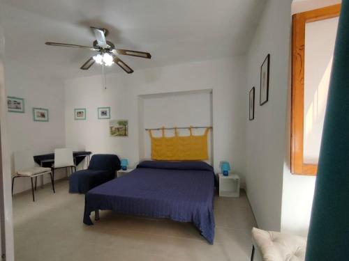 a bedroom with a bed and a ceiling fan at Casa Centurioni in Isola del Giglio