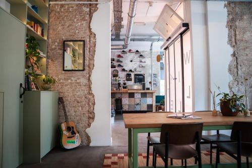 une salle à manger avec une table et une guitare dans l'établissement Will & Tate City Stay, à La Haye