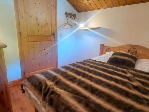 une chambre avec un lit avec une lumière sur le mur dans l'établissement Duplex chaleureux près du Grand Massif Express avec balcon et garage privé - FR-1-624-33, à Samoëns