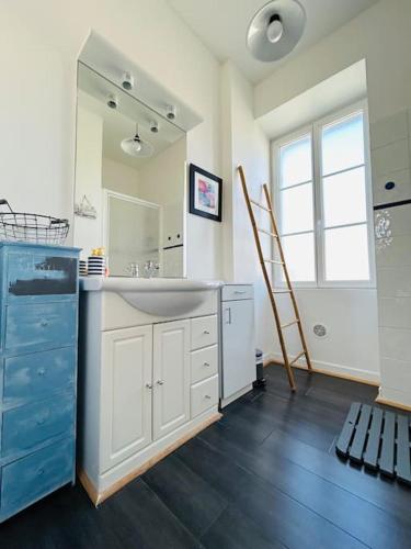 une salle de bain avec un lavabo et un grand miroir dans l'établissement La villa Marguerite, face mer avec terrasses, à Concarneau