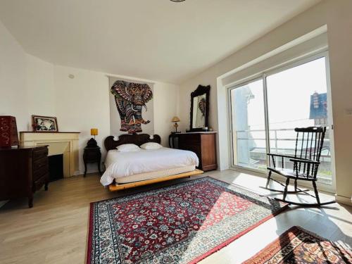 une chambre avec un lit et une grande fenêtre dans l'établissement La villa Marguerite, face mer avec terrasses, à Concarneau