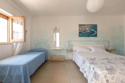 twee bedden in een kamer met blauwe en witte muren bij Villa delle Mimose by BarbarHouse in San Foca