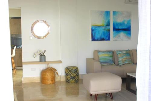 a living room with a couch and a mirror at Amar'e Aparthotel & Spa in Las Terrenas