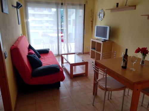 a living room with a red couch and a table at Apartamento 1ª línea de playa!!! in Cambrils
