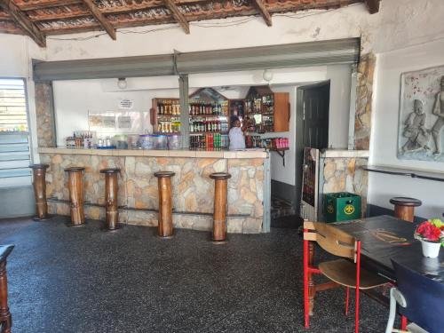 un bar con taburetes de madera en una habitación en Downtown Virgins Hotel, en Elmina