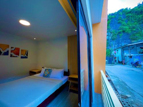 - une chambre avec un lit et une vue sur la rue dans l'établissement Vencejos Inn - El Nido, à El Nido