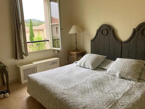 Un dormitorio con una cama grande y una ventana en Bijou Benoit, en Saint-Laurent-de-la-Cabrerisse