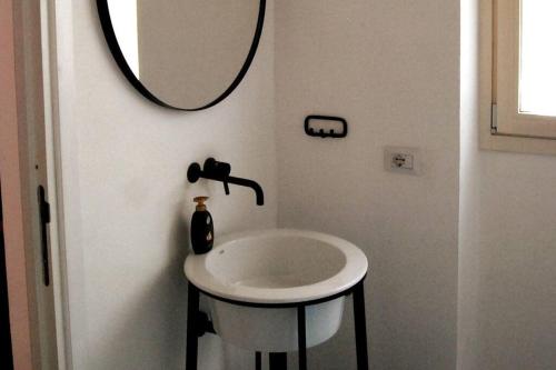 a bathroom with a white sink and a mirror at BassaMarea - Una sorpresa in Centro storico in Carloforte