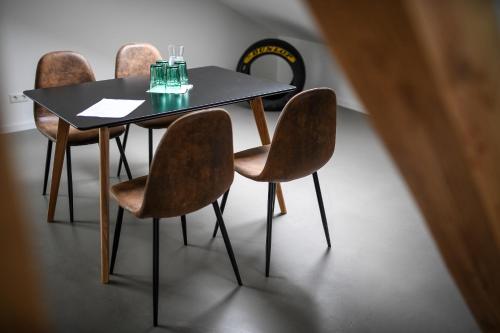 una mesa con cuatro sillas y una mesa con gafas. en Zweite Heimat Nürburg, en Reimerath