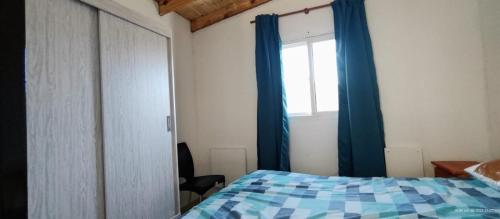 1 dormitorio con 1 cama y una ventana con cortinas azules en Pa'Que Te Vengas en Trapiche