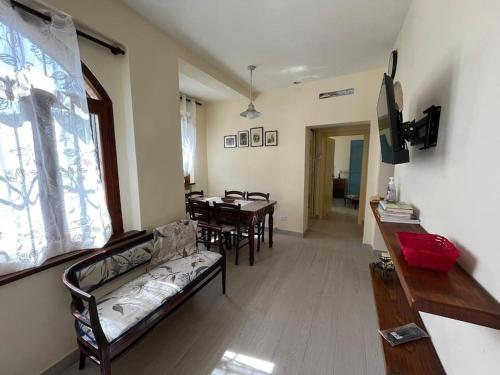 ein Wohnzimmer mit einem Sofa und einem Tisch mit Stühlen in der Unterkunft Costa del sole 42 in Cetona