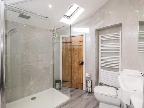 a bathroom with a shower and a toilet and a sink at The Stables in Worcester