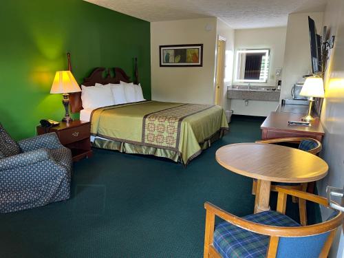 a hotel room with a bed and a table and a chair at Surry Inn - Dobson in Dobson
