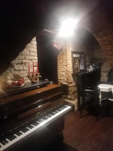 Un piano en una habitación con una mesa y velas. en Casa Huber, en Cîrţa