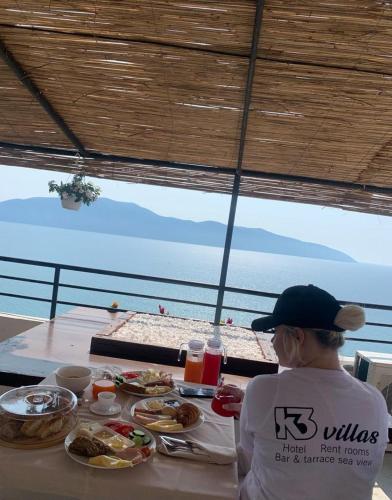 a person sitting at a table with plates of food at Hotel Kappa3 Villas in Vlorë