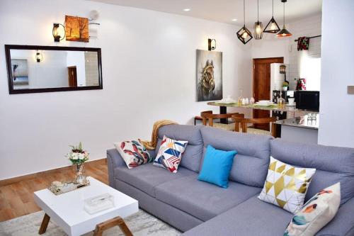 uma sala de estar com um sofá azul e uma mesa em Zuri Luxe 2BR apartment- Silversands Beach Malindi em Malindi