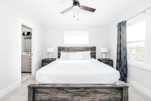 a bedroom with a white bed and a ceiling fan at Tranquil River Home in Asheville