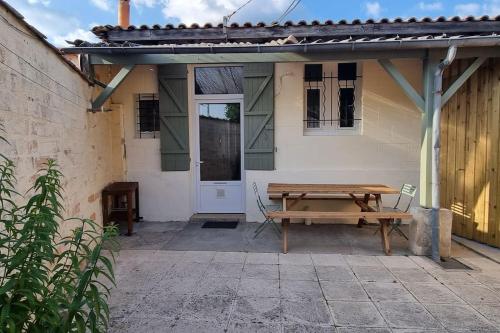 une table de pique-nique en bois devant une maison dans l'établissement Relaxing Holiday Home, à Lacanau