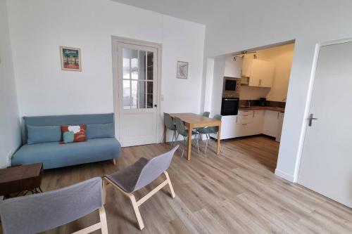 ein Wohnzimmer mit einem blauen Sofa und einem Tisch in der Unterkunft Relaxing Holiday Home YHH in Lacanau