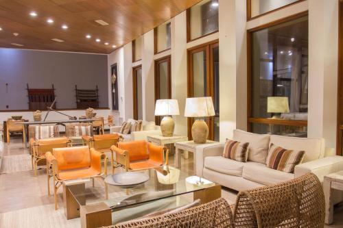 Una sala de estar con sofás y sillas y una mesa. en Hotel y Cabañas Hornitos - Caja Los Andes, en Hornitos